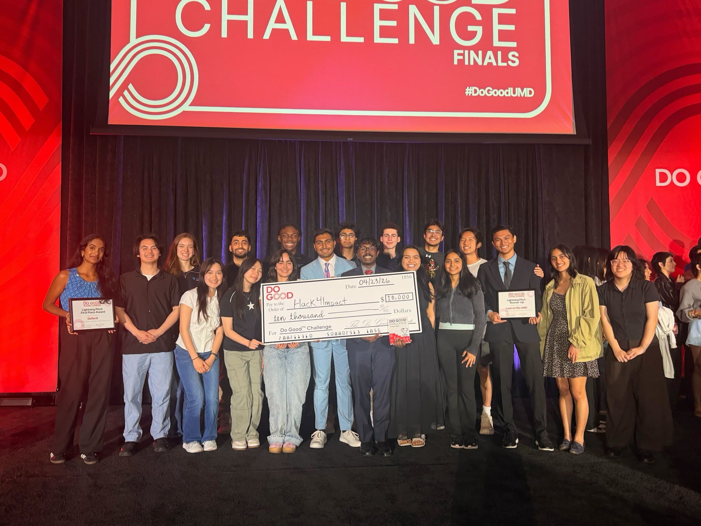 ori marx with the hack4impact team on stage holding a ten thousand dollar check at the do good challenge finals