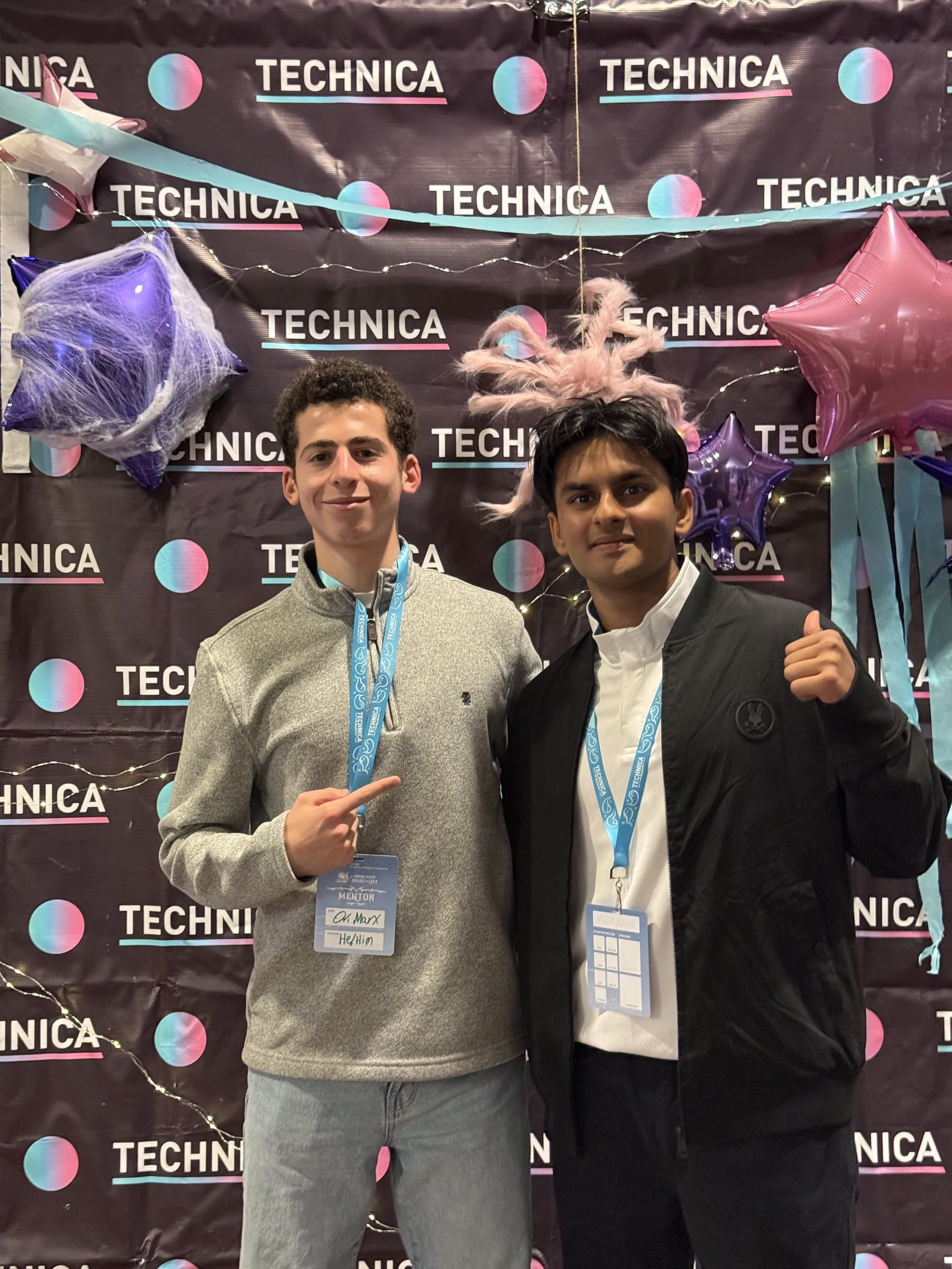 ori marx and a fellow mentor in front of the technica hackathon backdrop