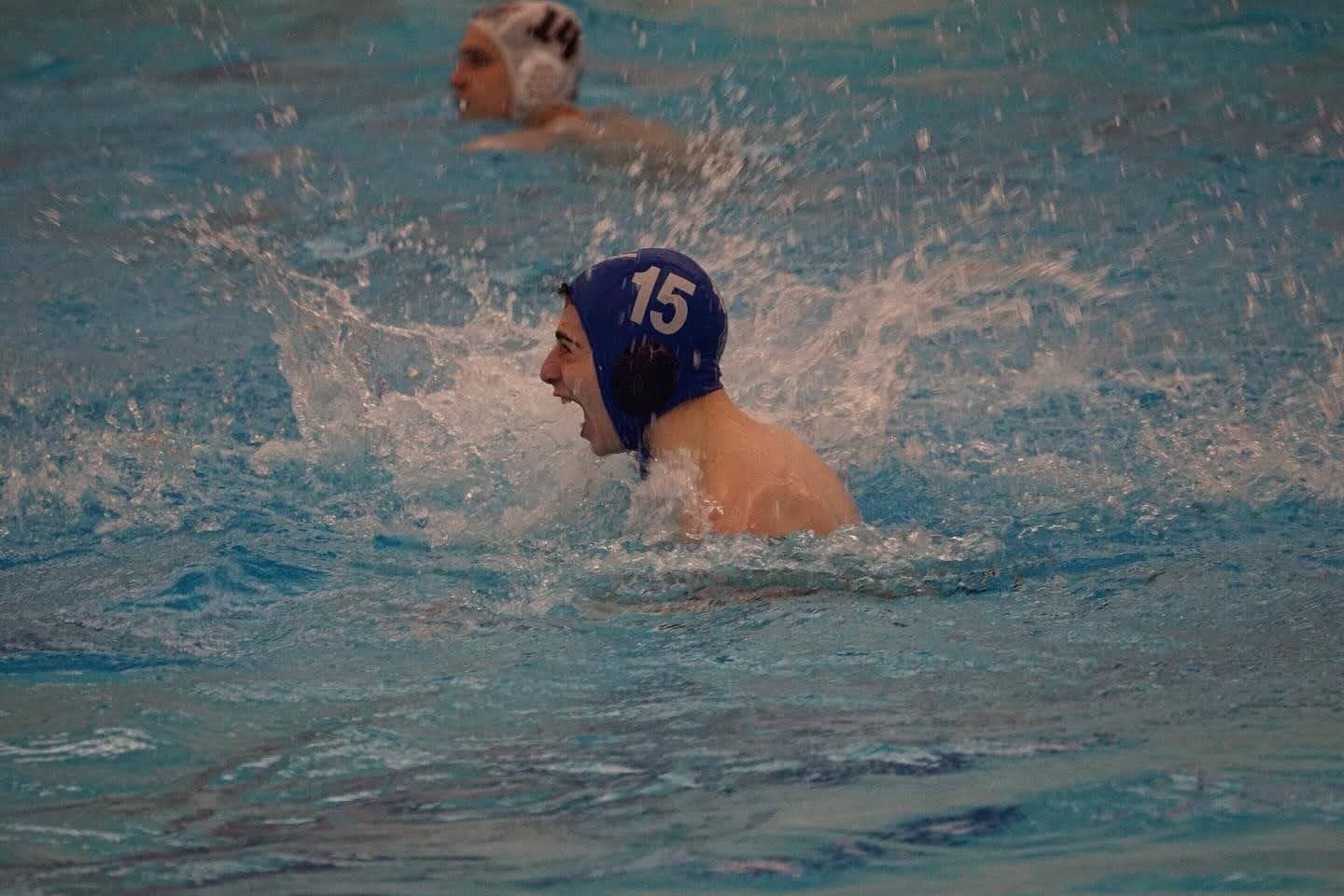 ori marx playing water polo in a blue number 15 cap mid-splash